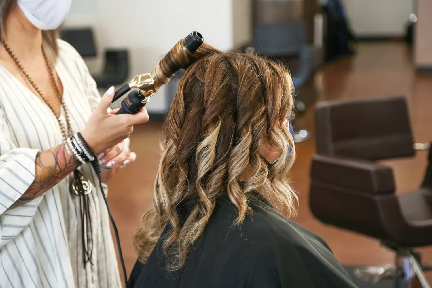 Stylist curling client hair