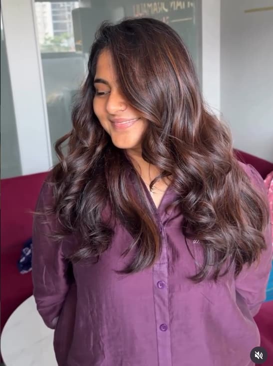 Smiling client with long wavy brown hair